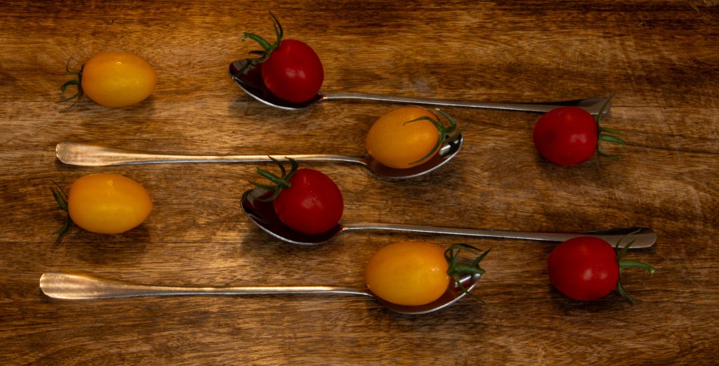 Cherry rajčice na žlicama na drvenoj podlozi