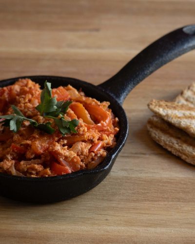 Jelo od jaja i rajčice posluženo u lijevanoj tavi s tostiranim kruhom, fotografija domaće hrane