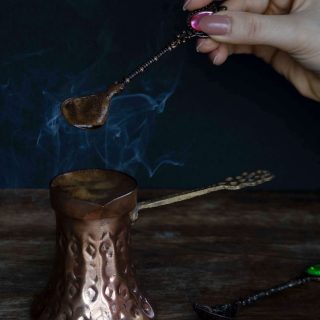 Ruka koja miješa kavu u bakrenoj džezvi